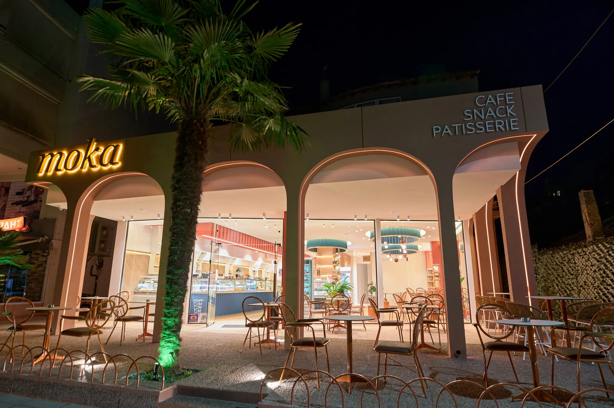 Άνετος εσωτερικός χώρος καθιστικού στο Moka Patisserie με μοντέρνα τραπέζια.